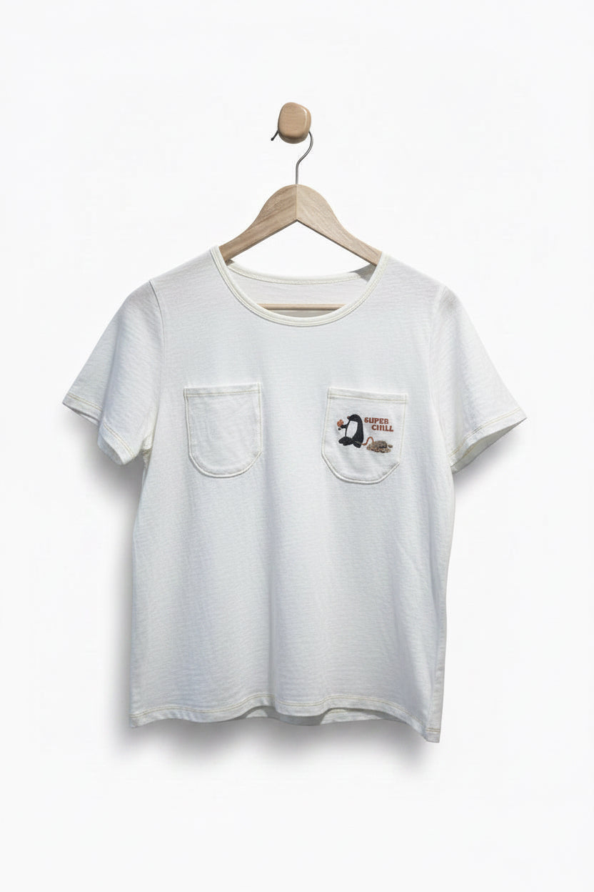White t-shirt with a pocket and graphic on a hanger against a plain background